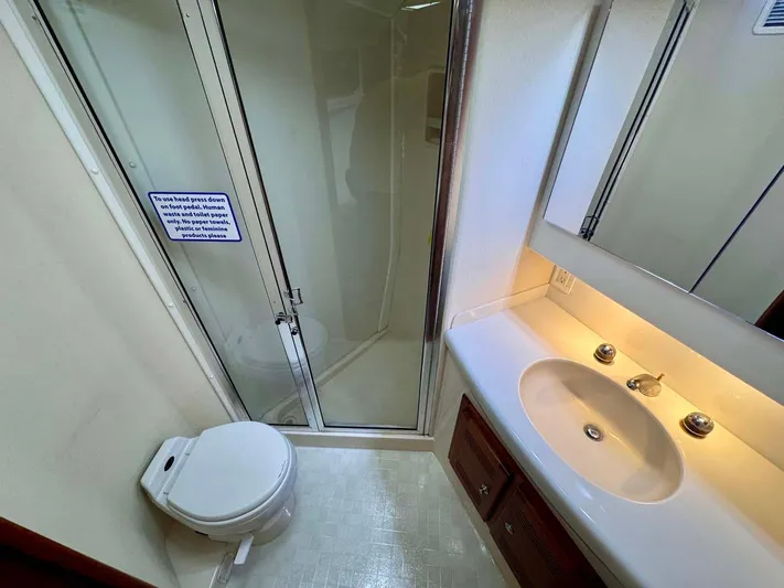 Bill Slayer Yacht Photos Pics Bathroom interior of 2002 Cabo 47 Flybridge Sportfisher with shower, sink, and toilet.
