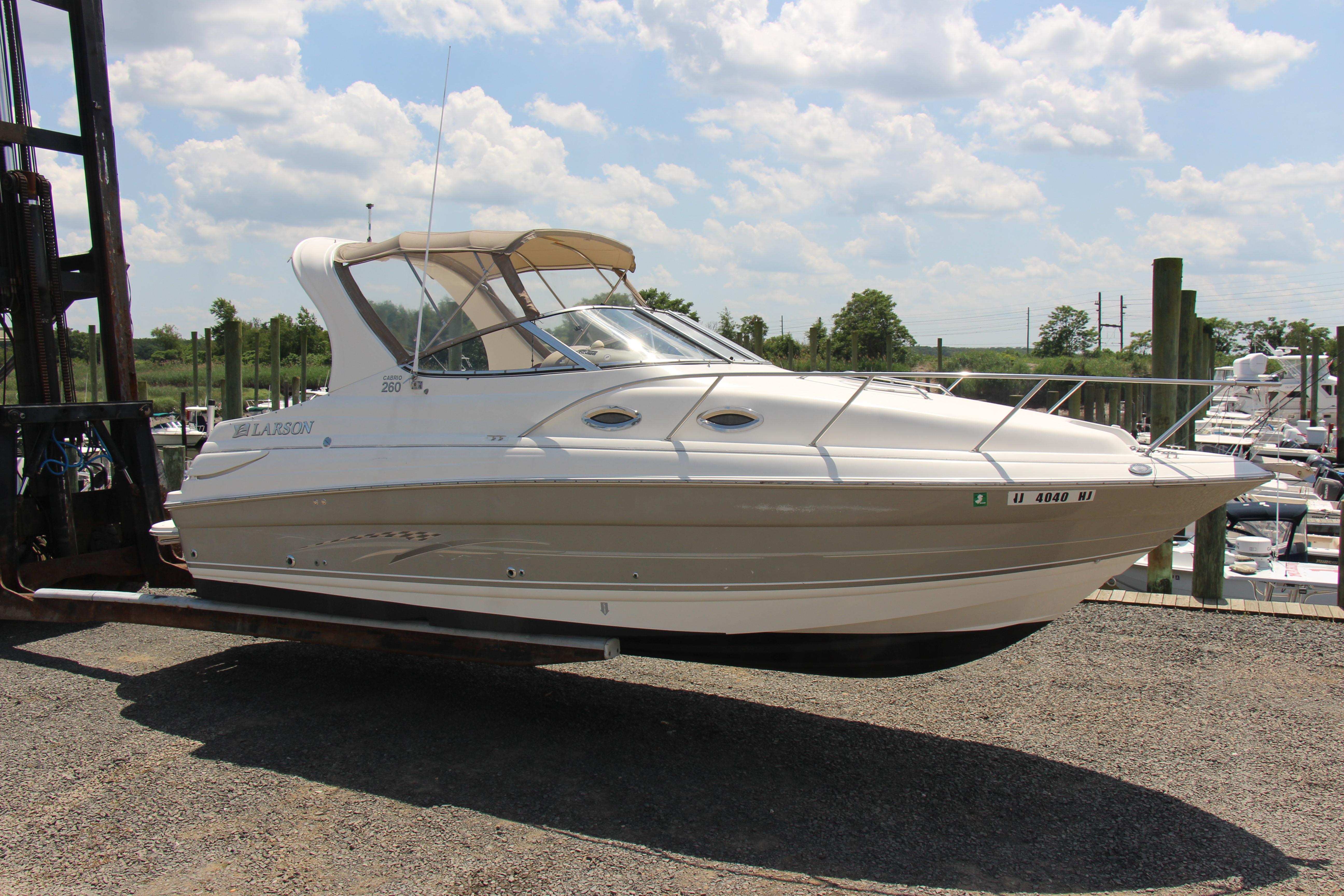 2008 Larson Cabrio 260 boat on a lift, under a clear blue sky.
