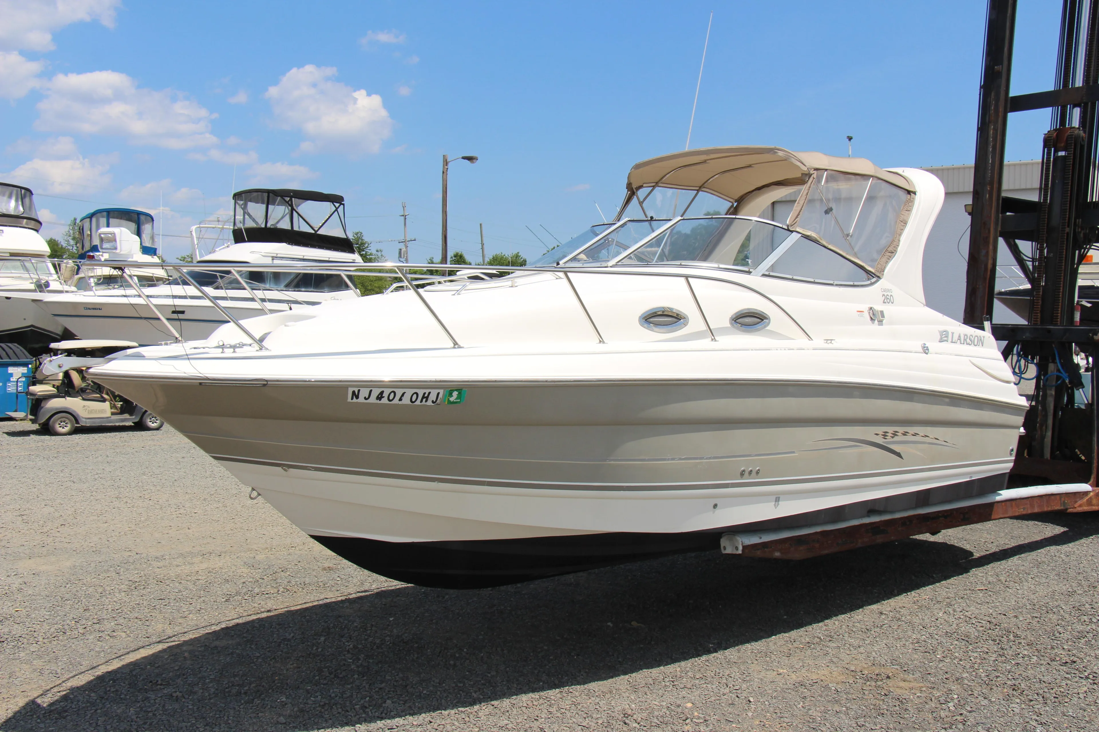 2008 Larson Cabrio 260 boat on a trailer in a marina setting.