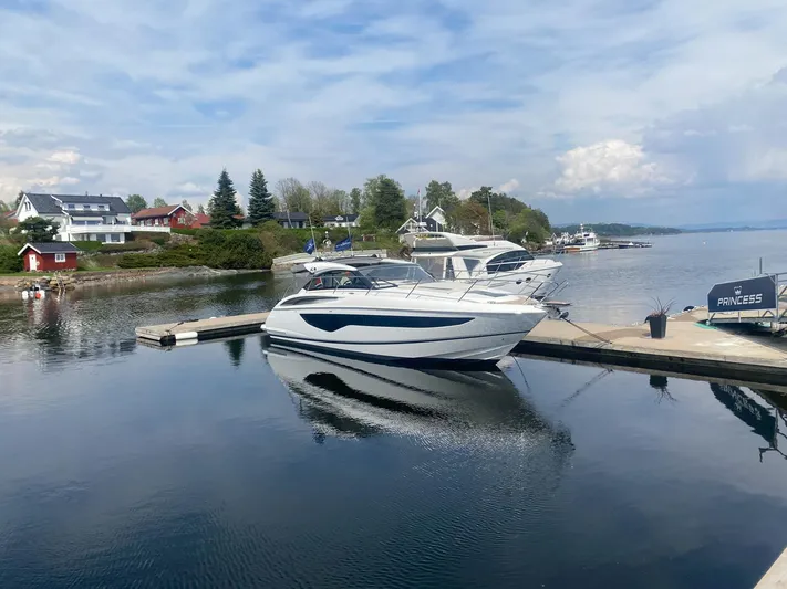 V40157 Yacht Photos Pics 2023 Princess V40 yacht docked at a serene marina with scenic surroundings.