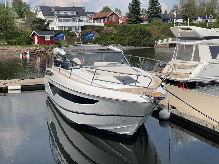 V40157 Yacht Photos Pics 2023 Princess V40 yacht docked at a marina, surrounded by scenic waterfront homes.