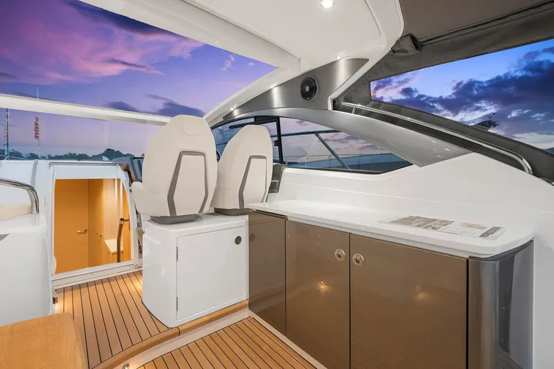 V40157 Yacht Photos Pics 2023 Princess V40 yacht interior with modern seating and cabinetry at sunset.