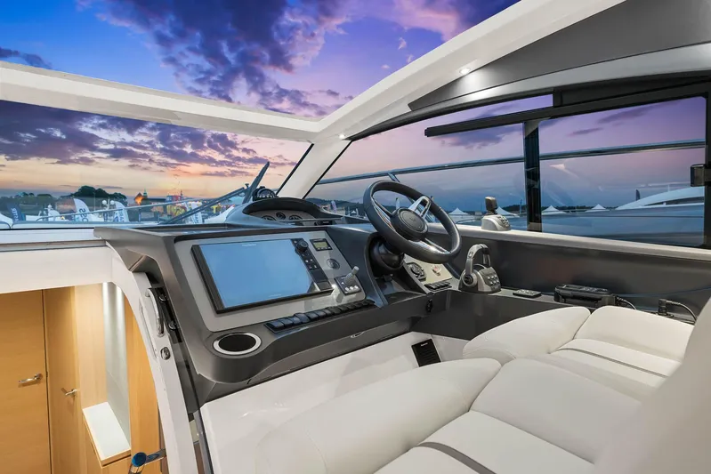 V40157 Yacht Photos Pics Modern 2023 Princess V40 yacht cockpit with luxurious interior and advanced navigation system at sunset.