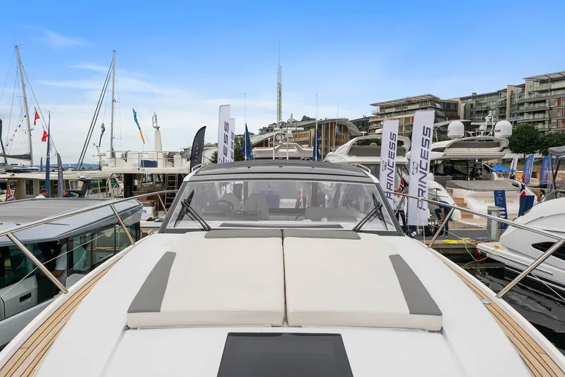 V40157 Yacht Photos Pics 2023 Princess V40 yacht displayed at a marina with other boats and buildings in the background.