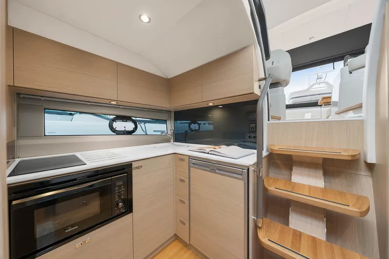 V40157 Yacht Photos Pics Modern kitchen interior of 2023 Princess V40 yacht with wooden cabinetry and appliances.