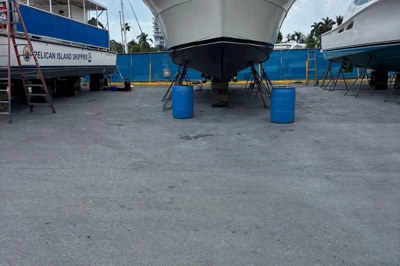  Yacht Photos Pics 1990 Viking 43 Convertible boat in dry dock, flanked by other vessels.