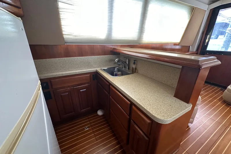  Yacht Photos Pics 1990 Viking 43 Convertible yacht kitchen with wood cabinets and countertop.