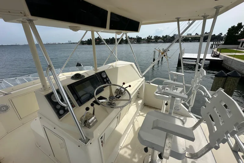  Yacht Photos Pics Helm of 1990 Viking 43 Convertible yacht with steering wheel and controls, overlooking marina.