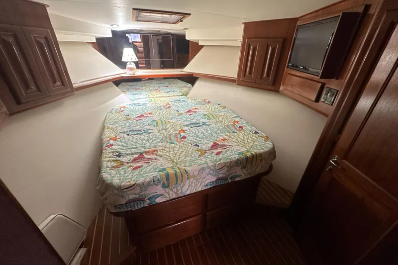  Yacht Photos Pics Cozy cabin interior of 1990 Viking 43 Convertible yacht with colorful bedding and wooden cabinetry.
