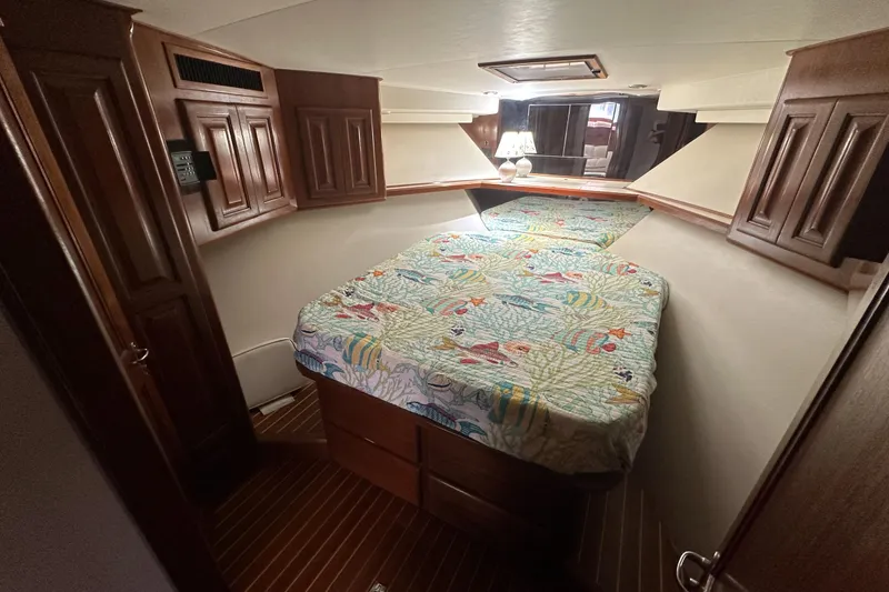  Yacht Photos Pics 1990 Viking 43 Convertible cabin with colorful bedding and wooden cabinetry.