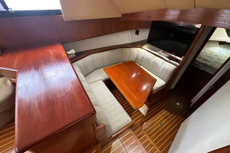  Yacht Photos Pics 1990 Viking 43 Convertible yacht interior with wooden dining area and cushioned seating.