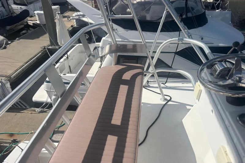 Distraction Yacht Photos Pics 2004 Luhrs 32 Open boat deck with steering wheel and seating at marina.