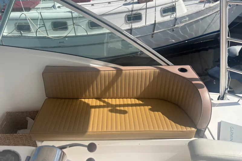 Distraction Yacht Photos Pics 2004 Luhrs 32 Open boat with tan cushioned seating and cup holder, docked near other boats.