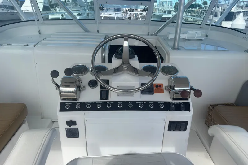Distraction Yacht Photos Pics Helm of 2004 Luhrs 32 Open boat with steering wheel and control panel.