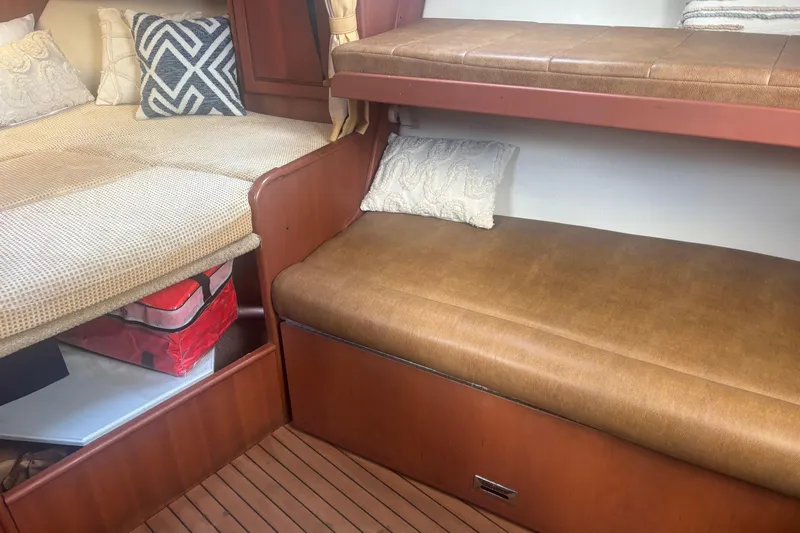 Distraction Yacht Photos Pics 2004 Luhrs 32 Open cabin interior with cozy bedding and wooden accents.