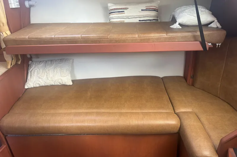 Distraction Yacht Photos Pics 2004 Luhrs 32 Open cabin interior with brown leather bunks and decorative pillows.