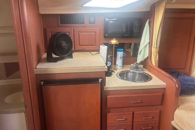 Distraction Yacht Photos Pics 2004 Luhrs 32 Open cabin kitchen with sink, microwave, and fan.