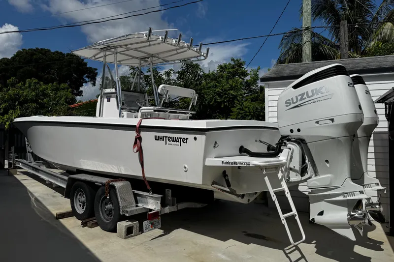  Yacht Photos Pics 2022 Whitewater 28 Open boat with Suzuki engines on a trailer, parked outdoors.