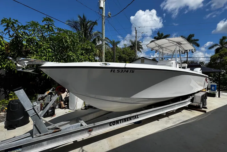  Yacht Photos Pics 2022 Whitewater 28 Open boat on trailer, parked outdoors under a clear blue sky.