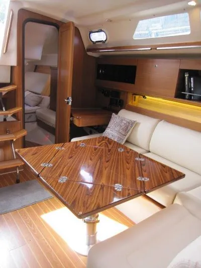 Hurkle Durkle Yacht Photos Pics Luxurious interior of 2024 Catalina 385 yacht with wooden table and plush seating.