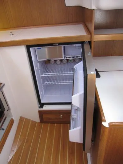 Hurkle Durkle Yacht Photos Pics 2024 Catalina 385 yacht interior with open fridge in wooden kitchen.