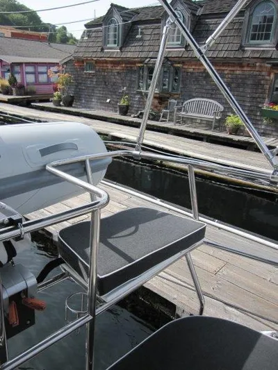 Hurkle Durkle Yacht Photos Pics 2024 Catalina 385 yacht with seating, docked near rustic waterfront buildings.