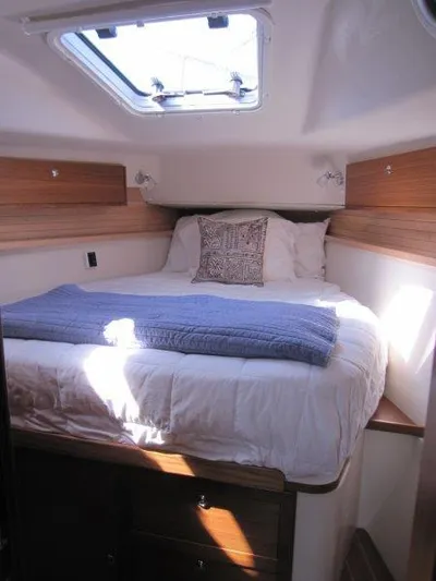 Hurkle Durkle Yacht Photos Pics 2024 Catalina 385 yacht cabin with cozy bed, wooden accents, and skylight.