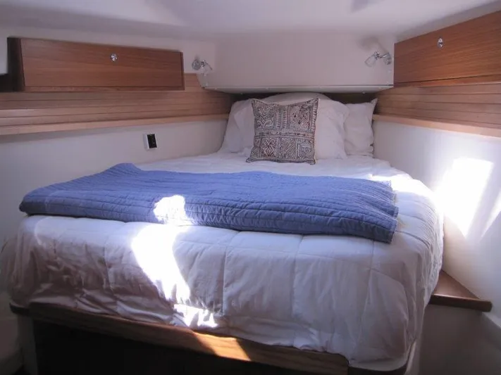 Hurkle Durkle Yacht Photos Pics Cozy bedroom in 2024 Catalina 385 yacht with wooden accents and soft bedding.