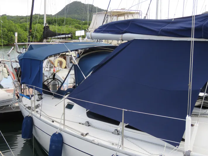 Yacht Photos Pics Jeanneau Sun Odyssey 40 sailboat, 2000 model, docked with blue covers and lush green backdrop.
