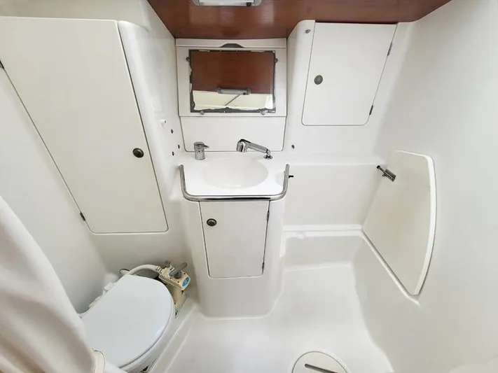  Yacht Photos Pics Bathroom interior of 2000 Jeanneau Sun Odyssey 40 yacht, featuring sink, toilet, and storage cabinets.