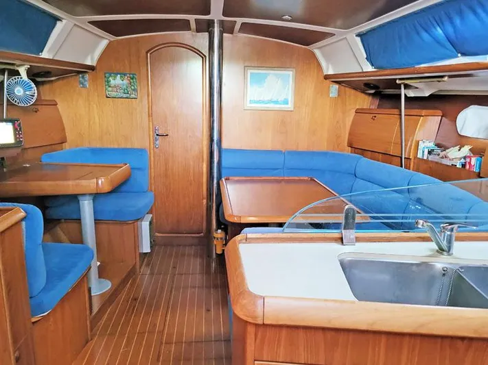  Yacht Photos Pics Interior of 2000 Jeanneau Sun Odyssey 40 yacht with blue seating and wooden finishes.