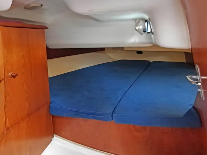  Yacht Photos Pics Cabin interior of 2000 Jeanneau Sun Odyssey 40 with blue cushions and wooden finish.