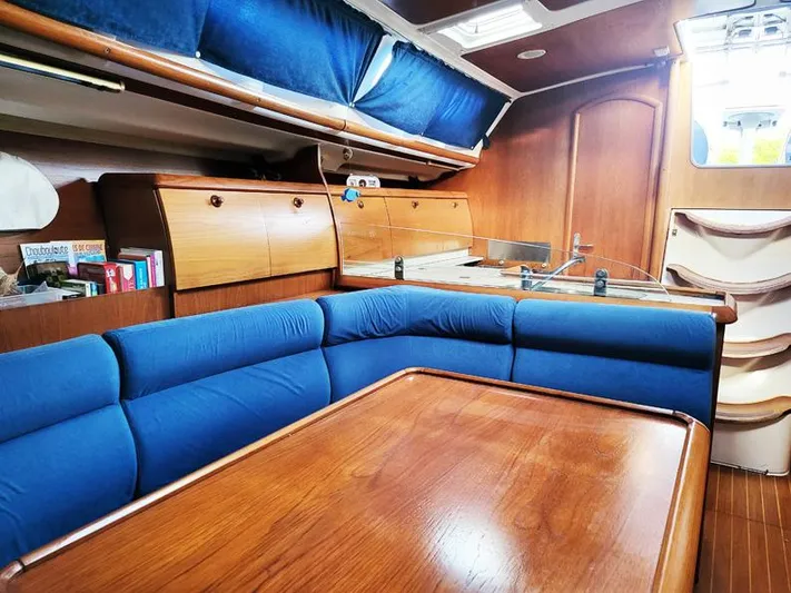  Yacht Photos Pics Interior of 2000 Jeanneau Sun Odyssey 40 sailboat with blue seating and wooden finishes.