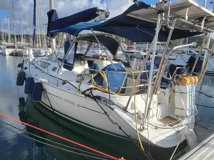  Yacht Photos Pics Jeanneau Sun Odyssey 40 sailboat, 2000 model, docked in a marina with blue covers.