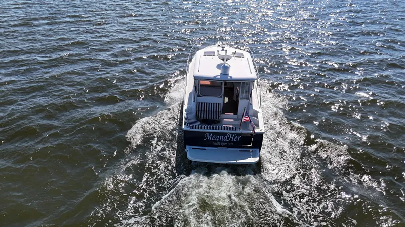  Yacht Photos Pics 2013 Back Cove 34 boat cruising on open water, rear view.