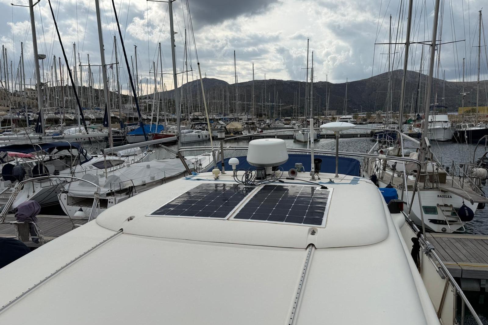 Elling E3 yacht from 2000 docked in a marina, featuring solar panels on the roof.