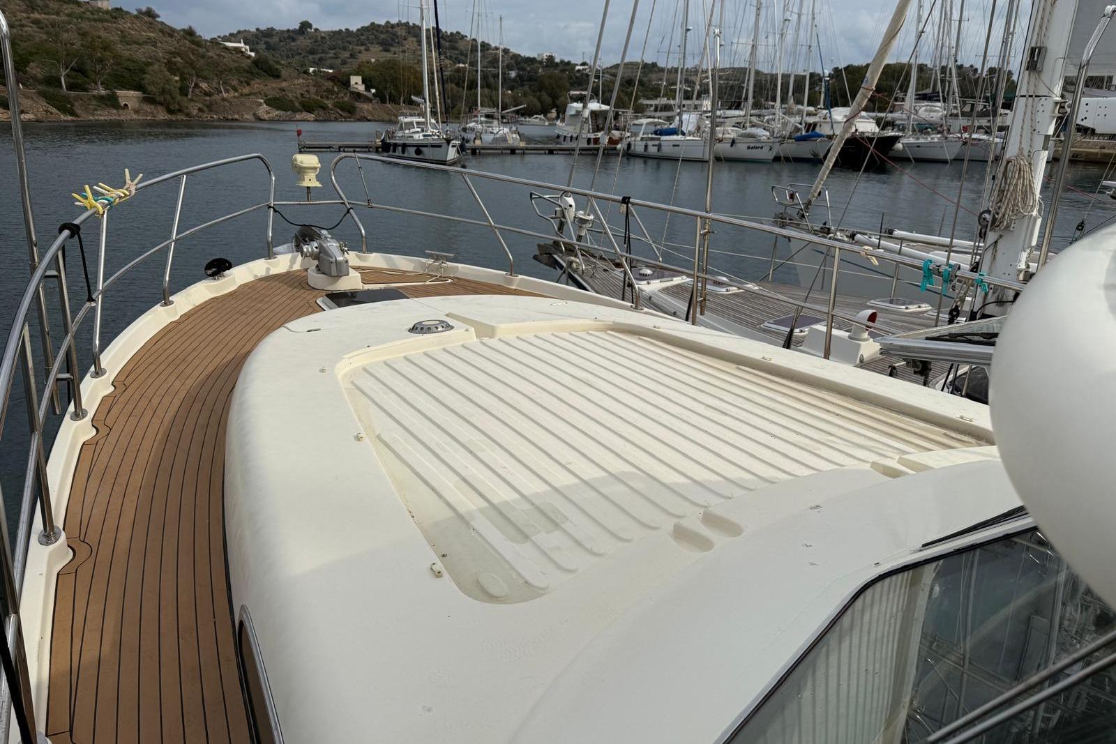 Deck of 2000 Elling E3 yacht docked in a marina, featuring wooden flooring.