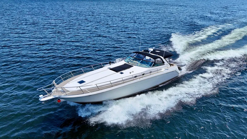 Top Gunns Yacht Photos Pics 1998 Sea Ray 500 Sundancer cruising on open water, creating a dynamic wake.