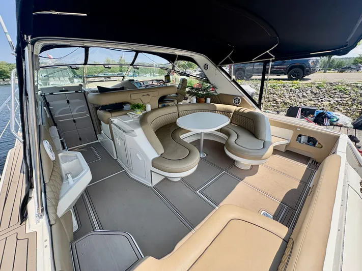 Top Gunns Yacht Photos Pics 1998 Sea Ray 500 Sundancer yacht interior with beige seating and table, docked by the water.