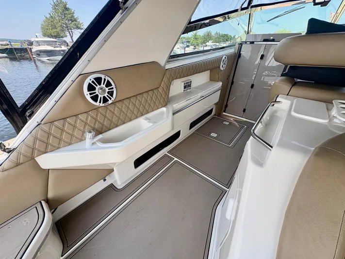 Top Gunns Yacht Photos Pics 1998 Sea Ray 500 Sundancer interior with beige seating, speaker, and storage compartments.