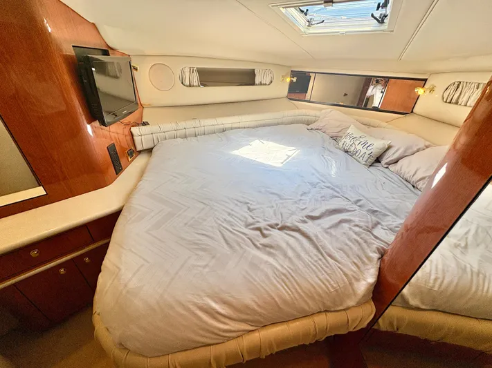 Top Gunns Yacht Photos Pics Luxurious bedroom interior of 1998 Sea Ray 500 Sundancer yacht with cozy bedding and TV.