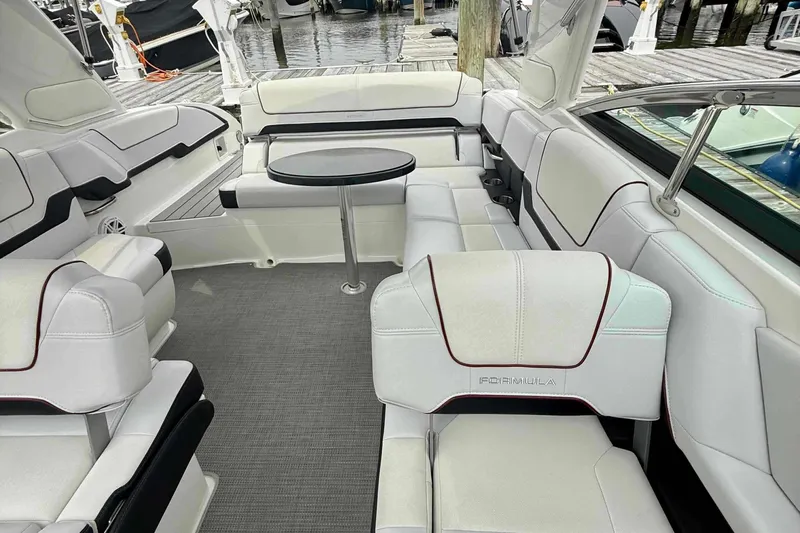 Yacht Photos Pics 2020 Formula 290 Bowrider interior with white seating and round table, docked at marina.