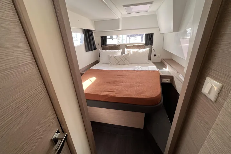  Yacht Photos Pics Luxurious cabin interior of 2023 Fountaine Pajot Tanna 47 yacht, featuring cozy bedding.