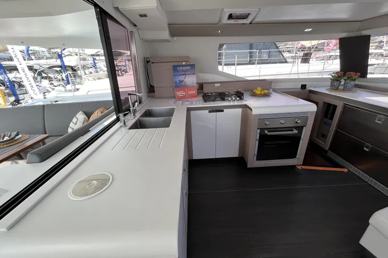  Yacht Photos Pics Modern kitchen interior of 2023 Fountaine Pajot Tanna 47 yacht, featuring sleek countertops and appliances.