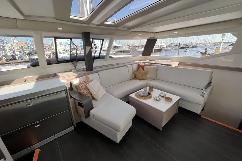  Yacht Photos Pics Luxurious interior of 2023 Fountaine Pajot Tanna 47 yacht with elegant seating and marina view.