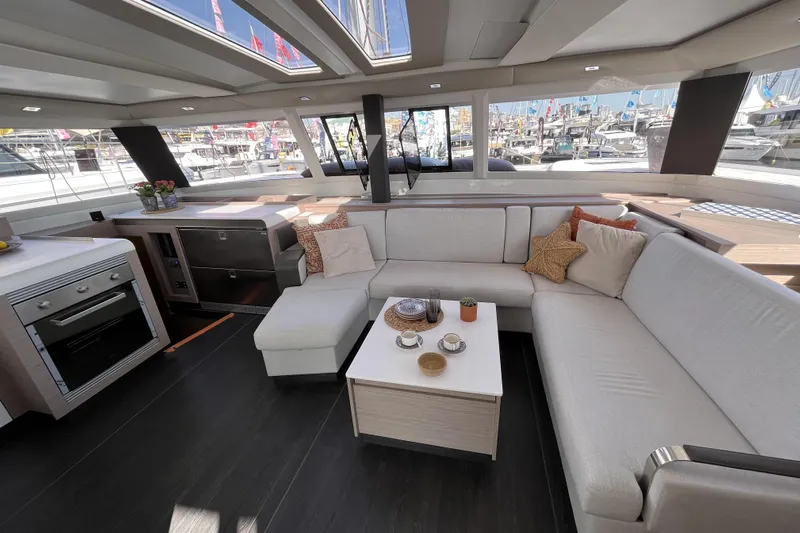  Yacht Photos Pics Luxurious interior of 2023 Fountaine Pajot Tanna 47 catamaran with modern kitchen and comfortable seating.