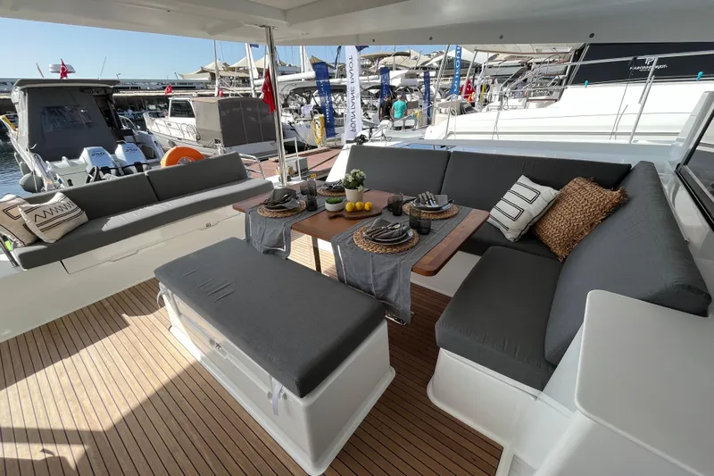  Yacht Photos Pics Luxurious 2023 Fountaine Pajot Tanna 47 yacht with elegant outdoor seating and dining area.