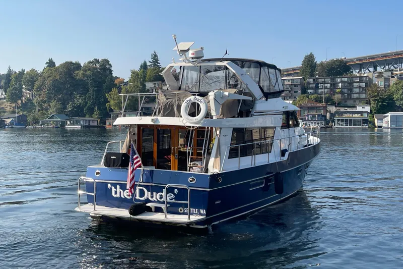 The Dude Yacht Photos Pics 1995 Ocean Alexander 486 yacht on a serene lake with scenic background.