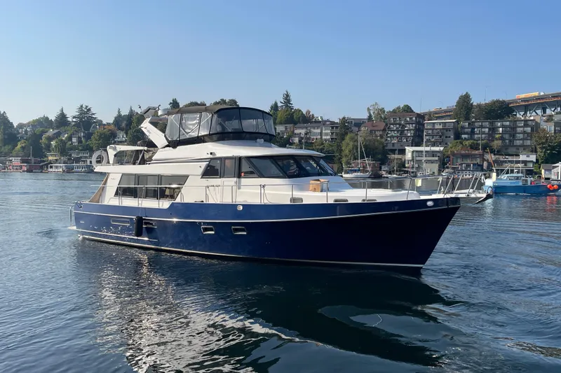 The Dude Yacht Photos Pics 1995 Ocean Alexander 486 yacht cruising on a calm waterfront with scenic background.
