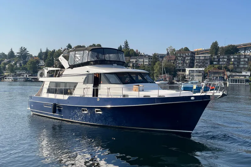 The Dude Yacht Photos Pics 1995 Ocean Alexander 486 yacht cruising on a calm waterfront with scenic background.